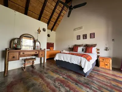 a bedroom with a bed and a dresser and a mirror at No 43 - The Eco Lodge in Hoedspruit