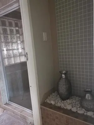 a shower with two vases sitting on a stone niche at Klyne Jiweel Guesthouse in Pretoria