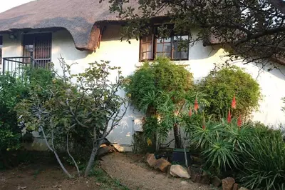 a white house with a thatched roof at 41 Ridge- self catering cottages in Midrand