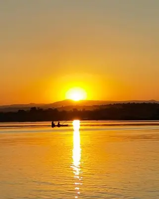 two people in a boat on the water at sunset at Lira Boutique Lodge in Thohoyandou