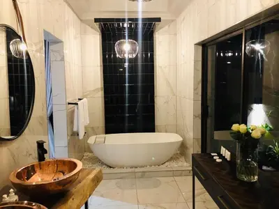 a bathroom with a large tub and a sink at Lira Boutique Lodge in Thohoyandou