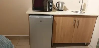 a microwave sitting on top of a counter next to a dishwasher at Langa's Gabedi Goshen in Pretoria