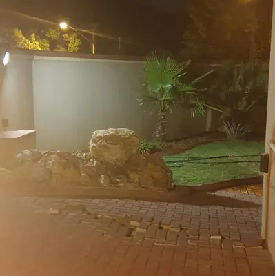 a rock garden at night with a palm tree at Langa's Gabedi Goshen in Pretoria