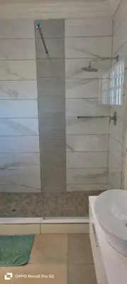 a bathroom with a shower and a sink at Langa's Gabedi Goshen in Pretoria