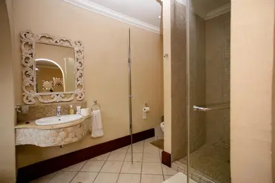 a bathroom with a tub and a sink and a shower at TDM's Boutique Guest House in Pretoria