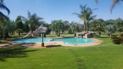 a swimming pool in the middle of a grass field at MixoSunrise Guesthouse & Spa in Pretoria