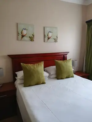 a bedroom with a bed with two birds on the wall at MixoSunrise Guesthouse & Spa in Pretoria