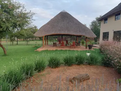a gazebo with a thatched roof in a yard at MixoSunrise Guesthouse & Spa in Pretoria
