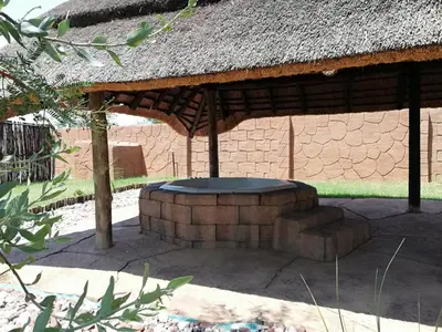 a building with a thatch roof and a circular seating area at MixoSunrise Guesthouse & Spa in Pretoria