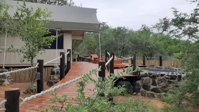 a wooden walkway leading to a building with a fence at Mountain View Safari Lodge in Hoedspruit