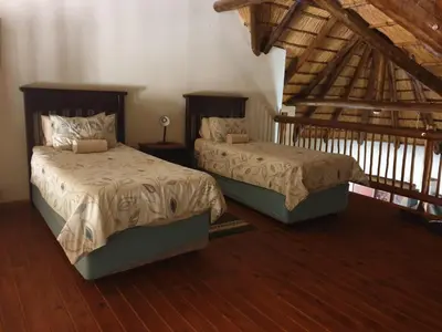 two beds in a room with wooden floors at Makhato Bush Lodge 86 in Bela-Bela
