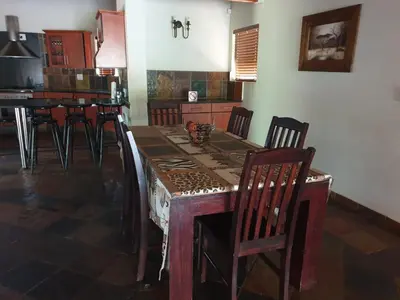 a kitchen with a wooden table and chairs at Makhato Bush Lodge 86 in Bela-Bela