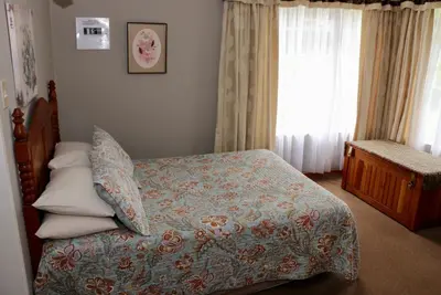 a bedroom with a bed and a window at Lakeview Cottages in Haenertsburg