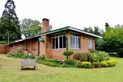 a brick house with a chimney on top of it at Lakeview Cottages in Haenertsburg