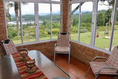 a porch with a table and two chairs and windows at Lakeview Cottages in Haenertsburg