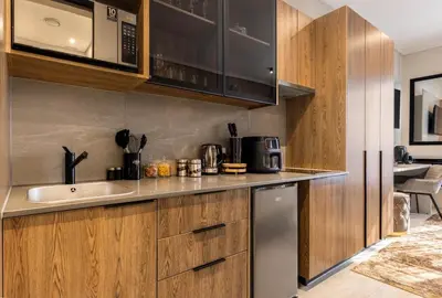 a kitchen with wooden cabinets and a sink at Menlyn Maine Residence Unit 1419 & 1028 in Pretoria