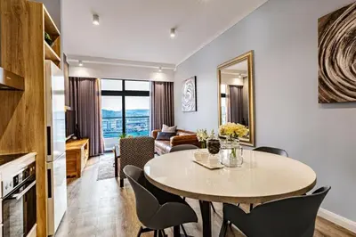 a dining room and living room with a table and chairs at Menlyn Maine Residence Unit 1419 & 1028 in Pretoria
