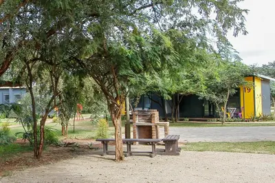 a bench sitting under a tree in a park at SleepOver Komatipoort in Komatipoort