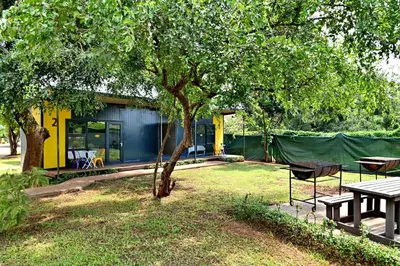 a house with a picnic table and a tree at SleepOver Komatipoort in Komatipoort