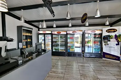 a fast food restaurant with a counter and drinks at SleepOver Komatipoort in Komatipoort