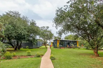 a garden with a walkway leading to a house at SleepOver Komatipoort in Komatipoort