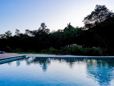 a pool of blue water with trees in the background at Lions Rock Rapids - Lodge in Hazyview