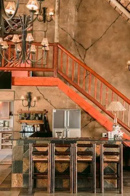 a kitchen with a microwave and a staircase at Tshukudiba Game Lodge in Tom Burke