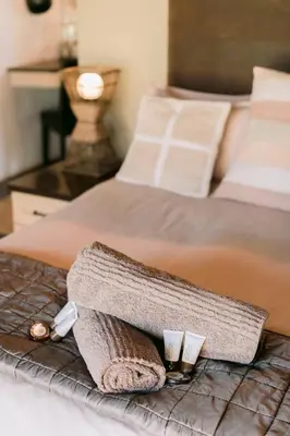 a bed with a towel and two cups on it at Tshukudiba Game Lodge in Tom Burke