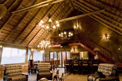 a large living room with a chandelier in a house at Tshukudiba Game Lodge in Tom Burke