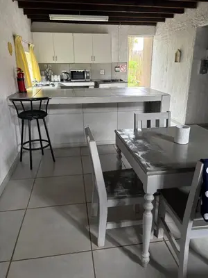 a kitchen with a table and two chairs and a counter at Le Soleil in Graskop