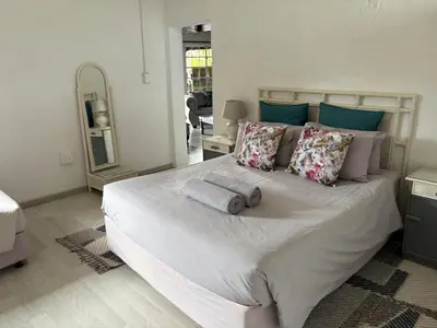 a bedroom with a large white bed with pillows at Le Soleil in Graskop