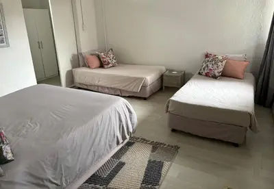 a small room with two beds and a couch at Le Soleil in Graskop