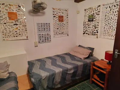 a bedroom with a bed and posters on the wall at Carpe Diem in Marloth Park