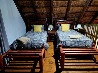 a bedroom with two beds and two benches in a room at Carpe Diem in Marloth Park