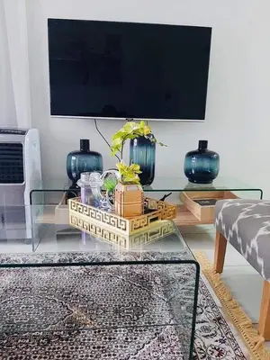 a living room with a glass table and a tv at The Blyde Crystal Lagoon penthouse in Pretoria