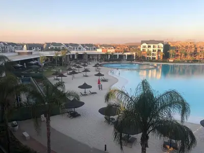a pool with umbrellas and palm trees in a resort at The Blyde Crystal Lagoon penthouse in Pretoria
