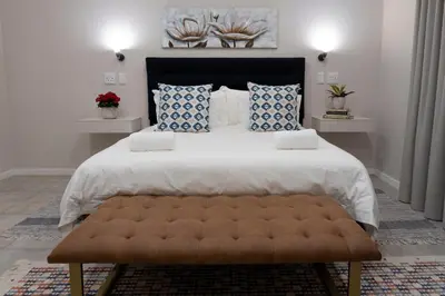 a bedroom with a large bed with blue and white pillows at Ruebys Apartment 202 in Dullstroom