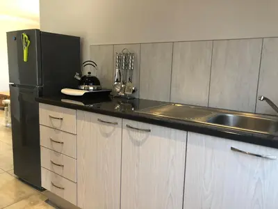 a kitchen with a black refrigerator and a sink at Ruebys Apartment 202 in Dullstroom