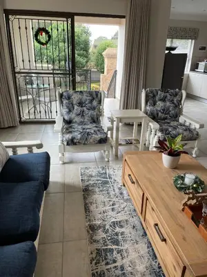 a living room with two chairs and a coffee table at Ruebys Apartment 202 in Dullstroom