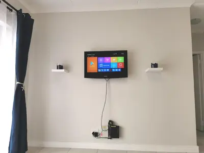 a flat screen tv on a white wall at The Blyde in Pretoria