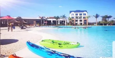 a swimming pool with a yellow boat on the beach at The Blyde in Pretoria