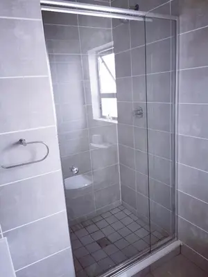 a bathroom with a shower with a glass door at The Blyde in Pretoria