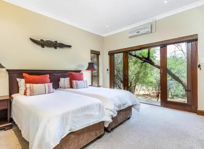 a bedroom with a bed with a fish on the wall at Elements Bush Villa 216 in Moheme