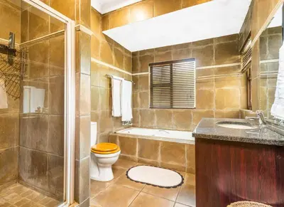 a bathroom with a toilet and a shower and a sink at Elements Bush Villa 216 in Moheme