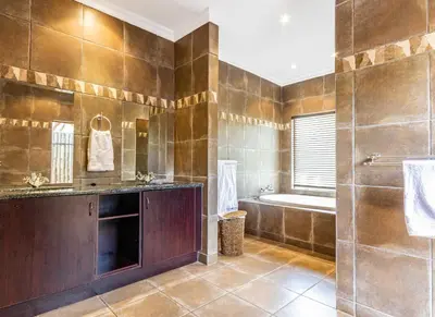 a large bathroom with a tub and a sink at Elements Bush Villa 216 in Moheme