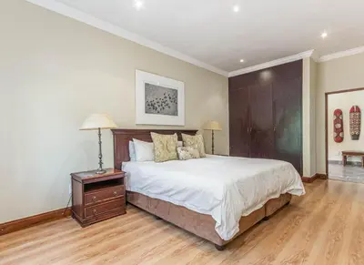 a bedroom with a large bed and a wooden floor at Elements Bush Villa 216 in Moheme