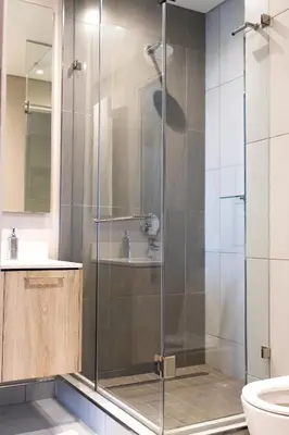 a shower with a glass door in a bathroom at The Residence Studio - Menlyn Maine in Pretoria