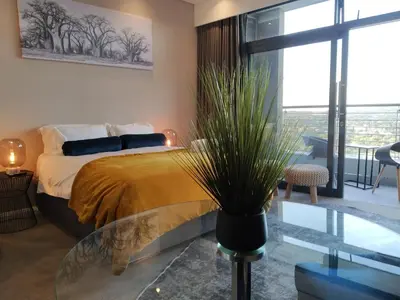 a bedroom with a bed and a glass table at The Residence Studio - Menlyn Maine in Pretoria
