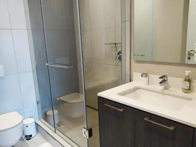 a bathroom with a sink and a glass shower at The Residence Studio - Menlyn Maine in Pretoria