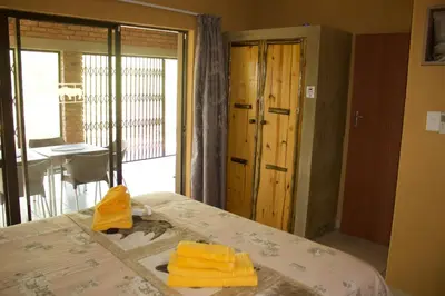 a room with a bed with yellow towels on it at Umhlanga Kruger in Marloth Park